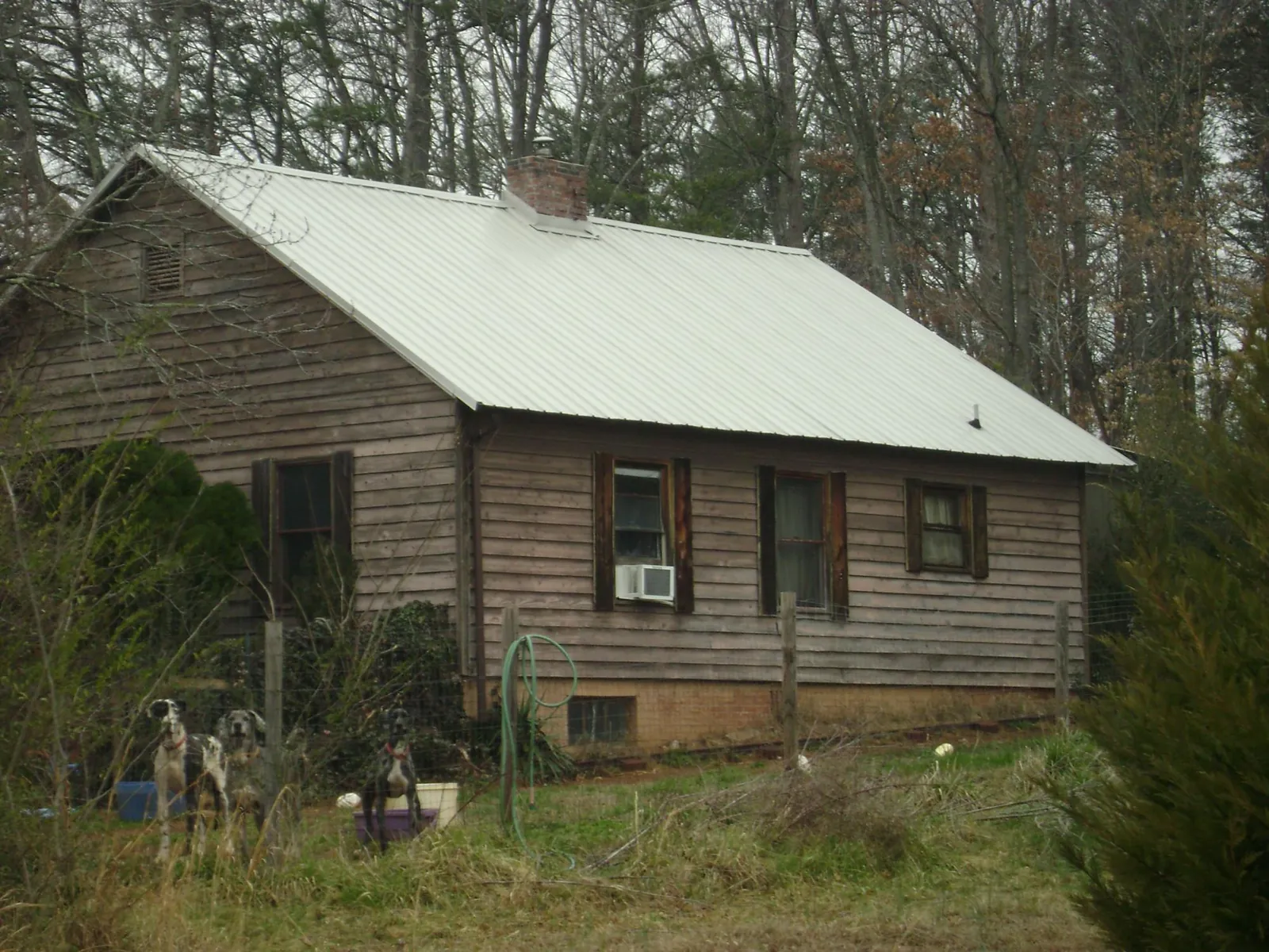 White metal roof on an old wood sided farmhouse, from a Metal Roof Installation job in North Liberty